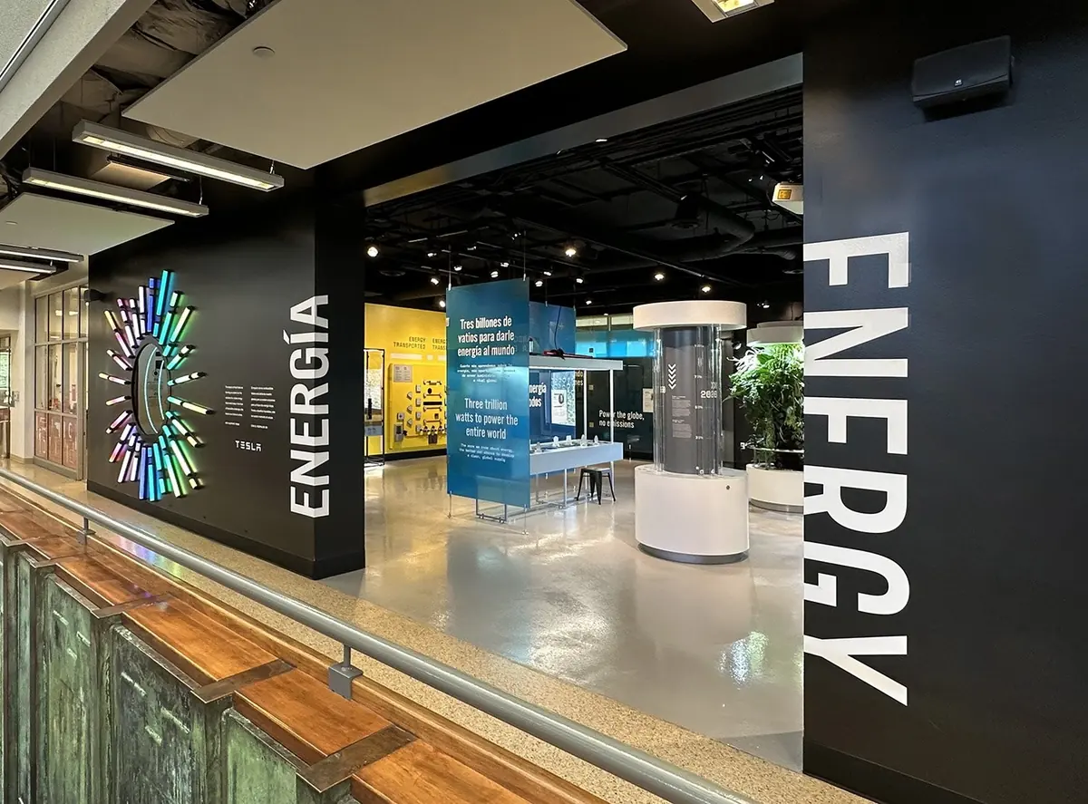 Entrance to the Energy / Energía exhibition, with a glowing circular sculpture and tall lettering