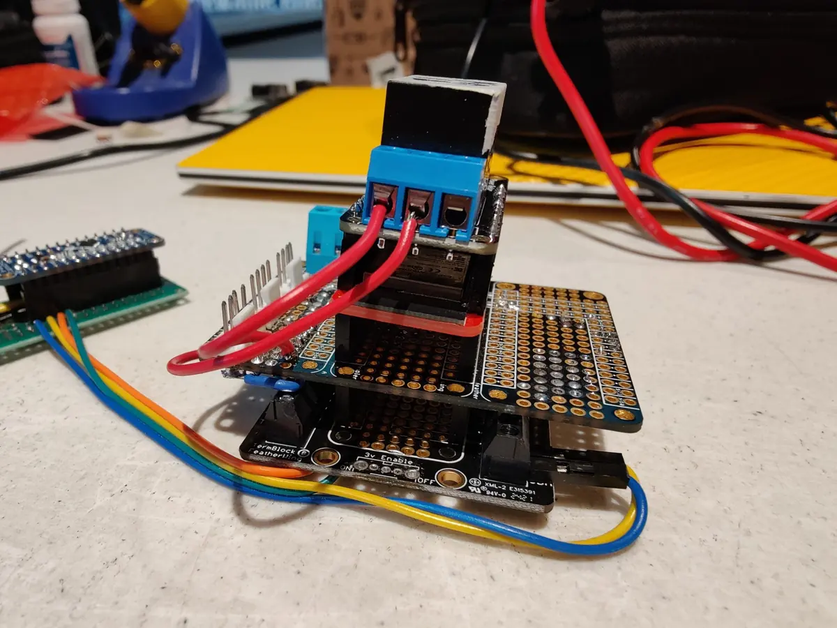 A stacked development board with relay modules on a workbench