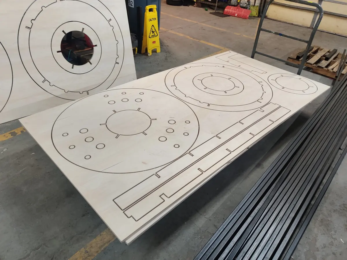 A plywood sheet with circular parts cut out by the CNC router