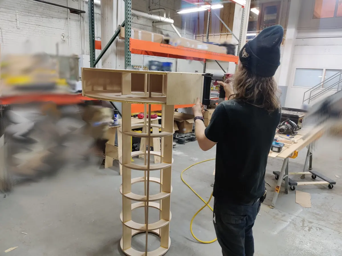 Fitting the first sheets of flexible birch around the top of the skeleton