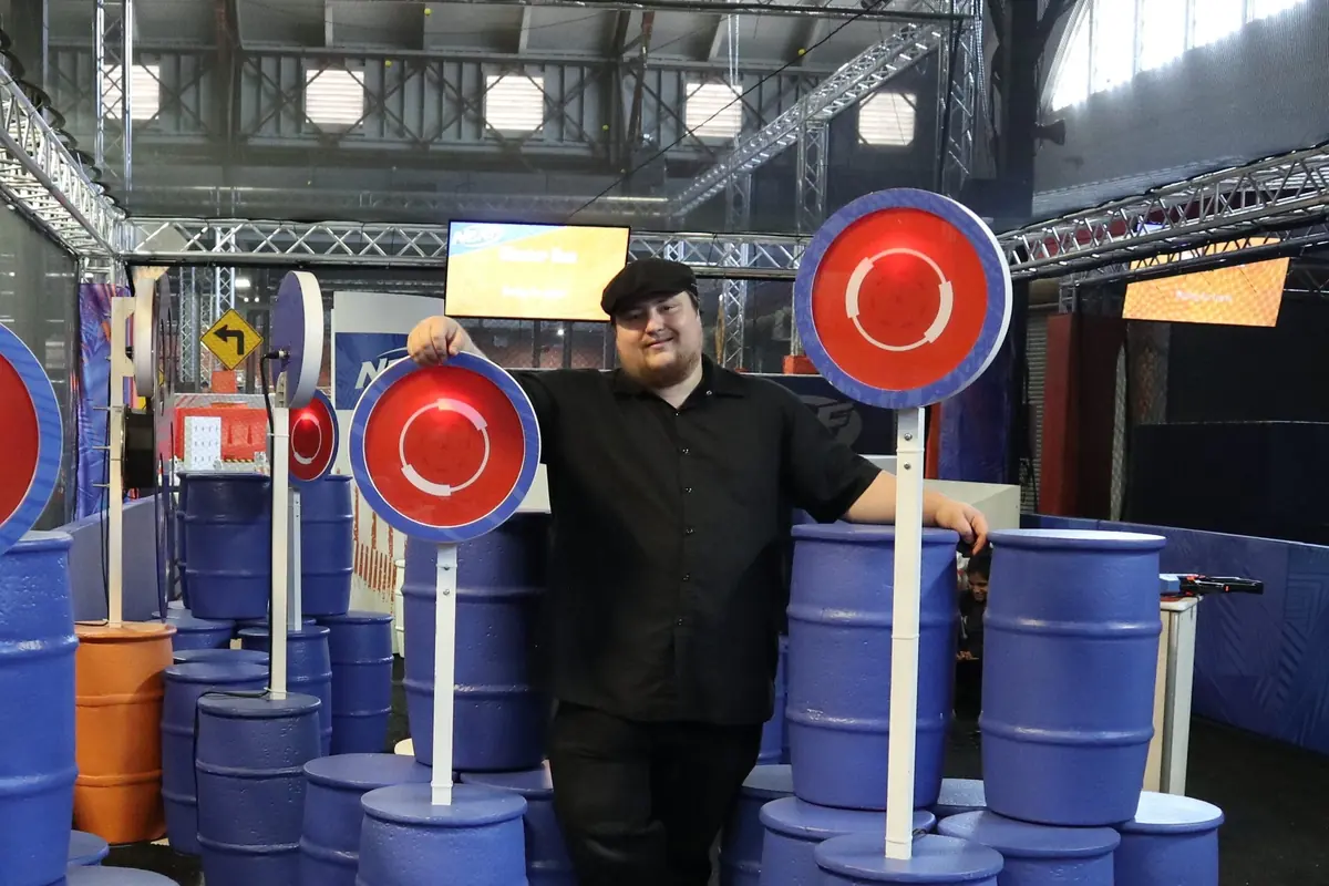 James standing among light-up NERF targets mounted on blue barrels