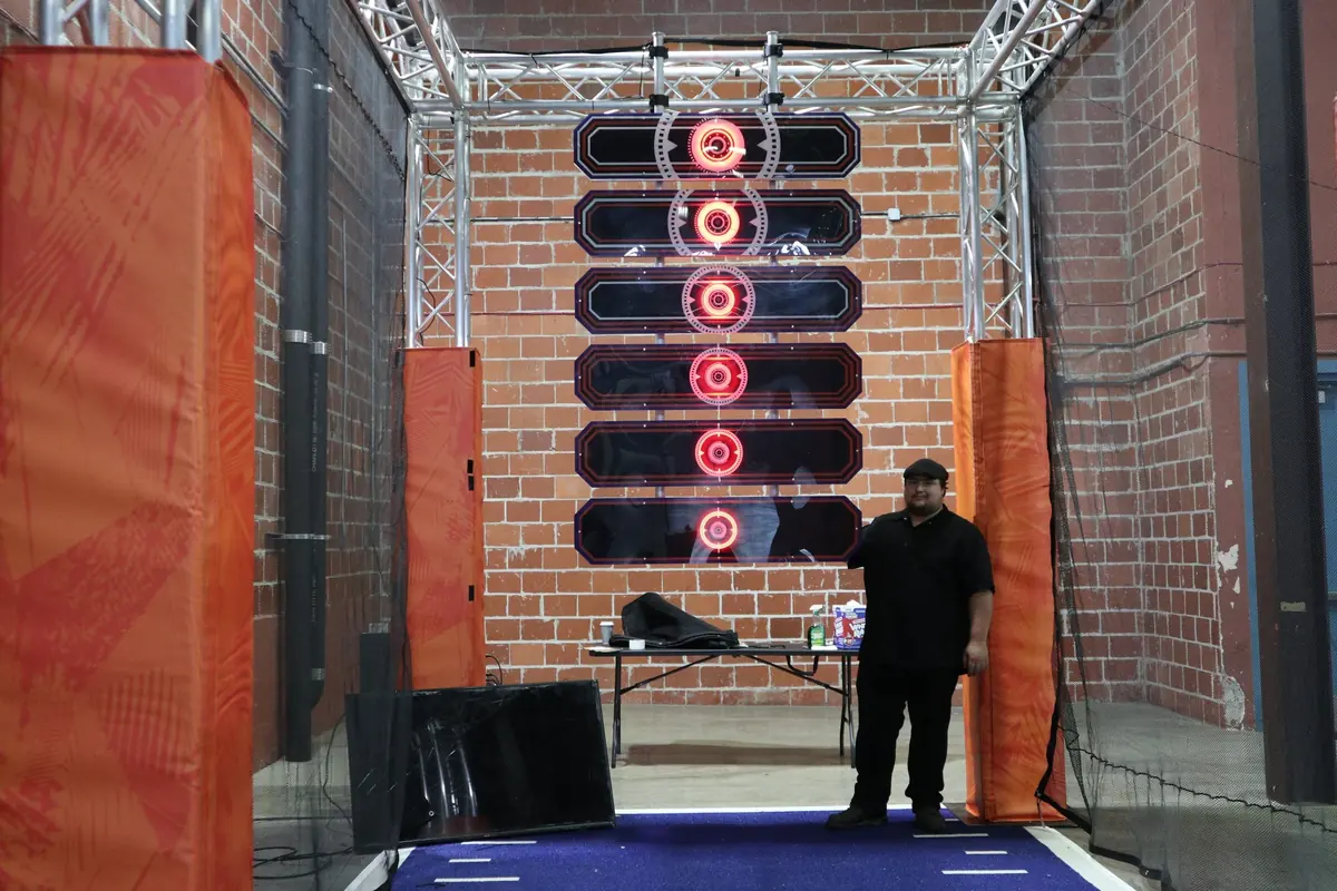 A tall stack of round light-up targets in front of a brick wall