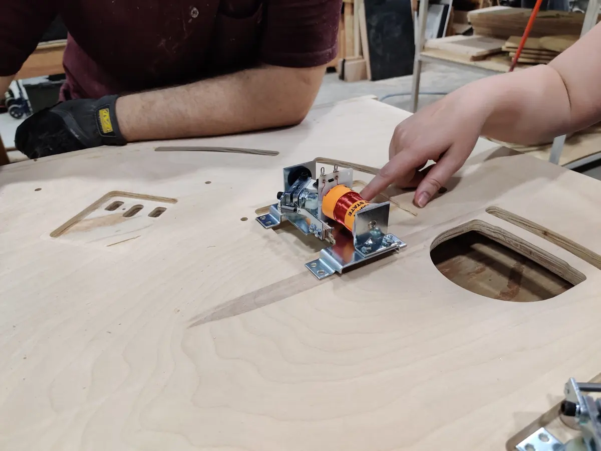 A hand pointing at a flipper solenoid cutout oriented the wrong way