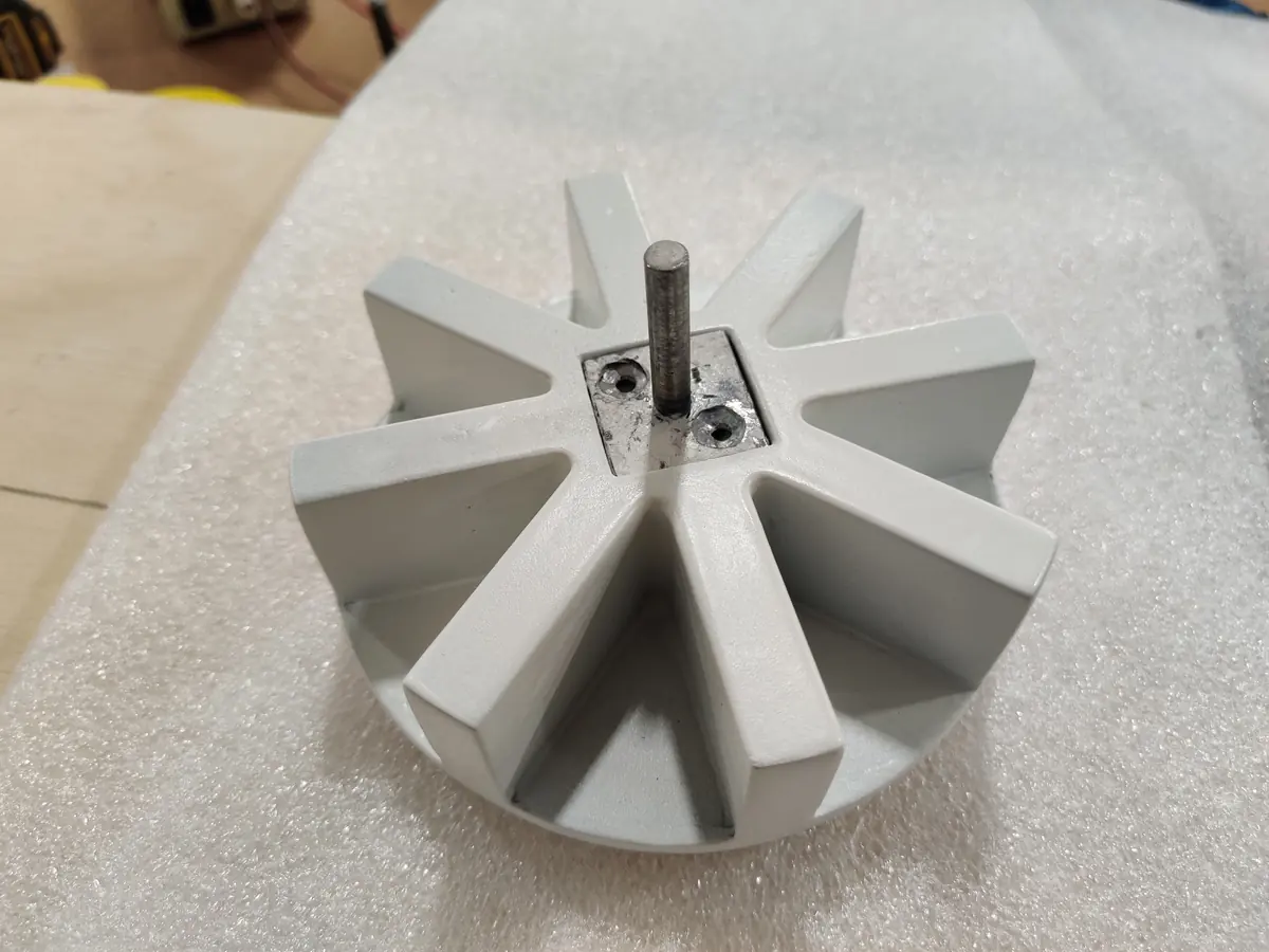 A white cast spinner with eight vanes on a metal shaft