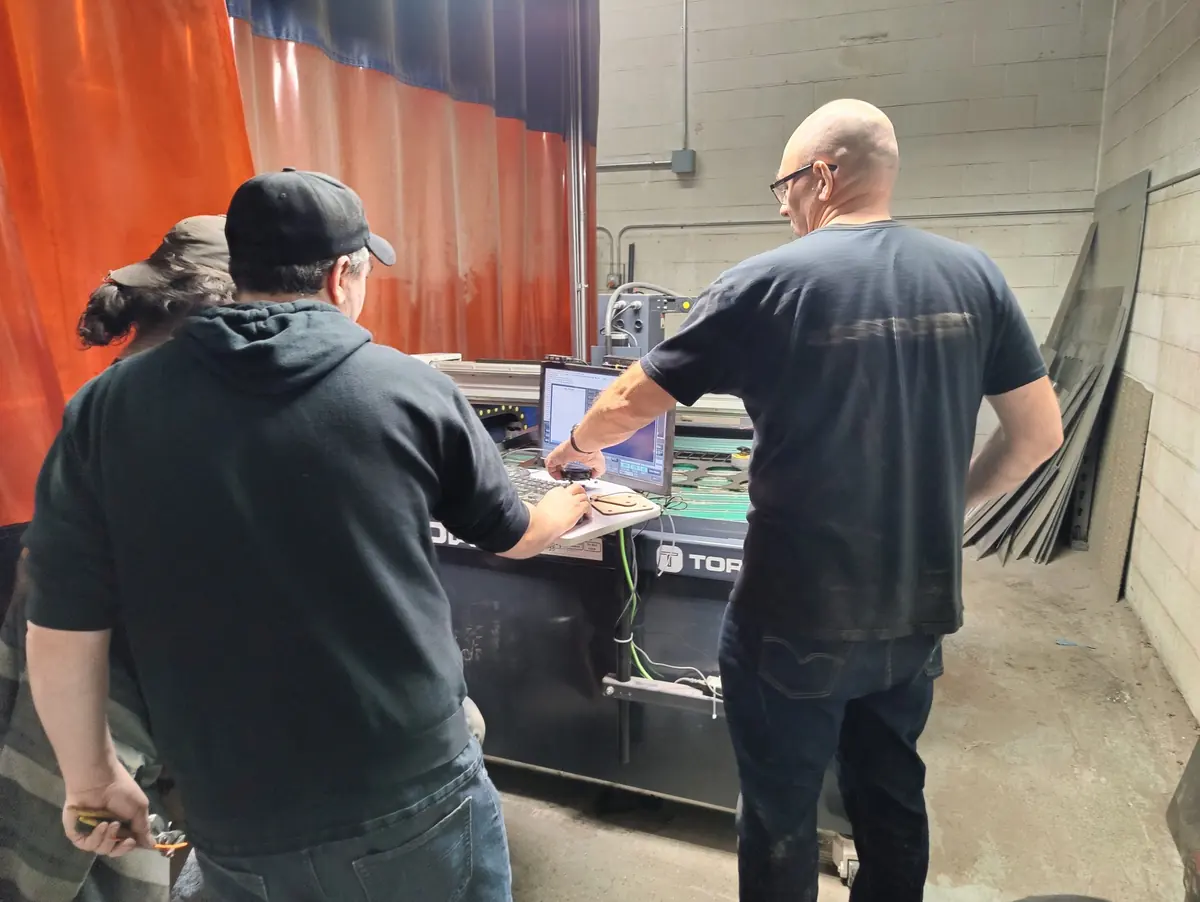 Two members setting up a job on the CNC plasma cutter’s screen